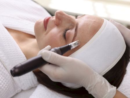 A gloved clinician injects a needle into a woman&rsquo;s face during a cosmetic treatment.