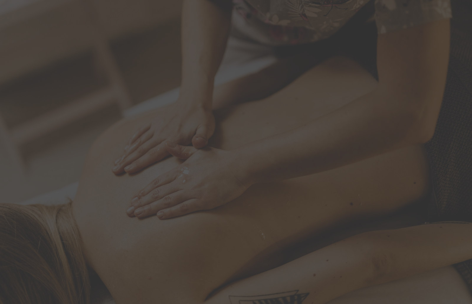 A person getting a gentle foot massage with hands on their feet, likely in a spa setting.
